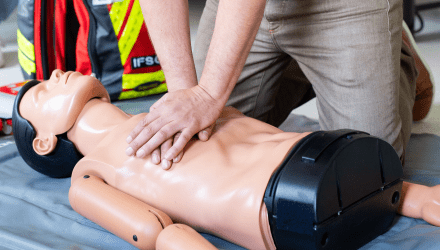 Formation aux gestes de premiers secours avec un formateur effectuant un massage cardiaque sur un mannequin de réanimation